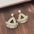 Close-up of handmade cream raffia woven triangular earrings with natural straw texture - Triangle Tassel Beige (A306)