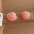 Close-up of pink square candy-colored stud earrings with smooth macaron resin finish - Square / Pink