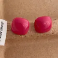Close-up of bright pink candy-colored square heart studs on a textured brown base - Square / Rose Red