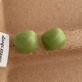 Close-up of avocado green square stud earrings with smooth glossy enamel finish - Square / Green