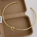 Detail einer goldenen Knotenhalskette mit Kugelenden in einer rustikalen Geschenkbox - Großer Knoten / Gold (G58)