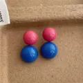 Dettaglio macro di eleganti orecchini a sfera bicolore in rosa vivace e blu brillante - Rosa Fucsia/Blu