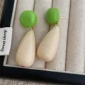 Detailed shot of green and cream acrylic water drop earrings on a jewelry display box - White And Cyan (L-18)