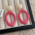 Retro-Harz-Ohrringe mit cremefarbenem Stecker und rosa Kreis auf Stoff-Display - Fuchsia