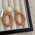 Detail von Vintage-Resin-Ohrringen in Karamell und Creme auf beigem Samttablett - Khaki