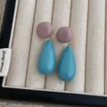 Close-up of contrast acrylic drop earrings in purple and cyan blue on a beige tray - Blue And Purple (L-18)