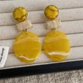 Detail view of yellow resin geometric earrings with marble texture on jewelry box - Yellow