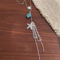 Detail of starfish and shell charms with white beaded tassel on silver steel chain - Starfish Style