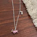 Detail van de teckelketting met hond in roze trui en een zilveren botvormige hanger - Roze