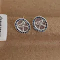 Close-up of bow earrings with purple cubic zirconia on rustic textured background - Oval Blue Style (L-50) / Blue