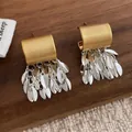 Vue détaillée de boucles d'oreilles à pompons feuilles bicolores style vintage chic - Or