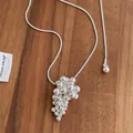 Detail of silver grape cluster pendant necklace on warm wood background texture - Silver