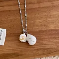 Macro detail of natural stone teardrop pendant and shell charm on silver chain - White Style (E100)