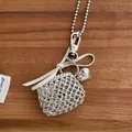 Detailed view of silver braided heart pouch pendant on a beaded sweater chain with bow - White Bowknot Style / Silver