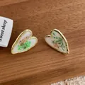 Detailed close-up of heart-shaped gold-rimmed earrings with embedded colorful dried flowers - Small / White (K-92)
