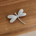 Spilla a libellula d'argento placcata oro 18K con ali testurizzate su legno scuro - Argento