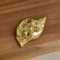 Macro shot of 18K gold plated conch brooch showing realistic metal texture and spiral details - Gold Conch Style (E-268)