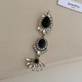 Macro view of vintage style gold earrings with black gemstones and clear crystals detail - Distressed Black