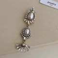 Macro view of vintage flower brooch with pearls and crystals on beige fabric texture - Distressed White