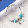 Detail of silver alloy bracelet with starfish, turtle, and shell charms on white fabric - Silver Teal Starfish Turtle Style (3)