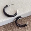 Vue détaillée des boucles d'oreilles en C avec cuir gaufré foncé sur base argentée - Café Foncé