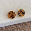 Nahaufnahme goldener runder Ohrstecker mit Leopardenmuster im edlen Vintage-Design - Rundes Leopardenmuster