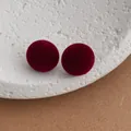 Close-up of wine red velvet stud earrings on a textured stone tray with detailed texture - Burgundy
