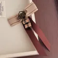 Detail of vintage beige woven ribbon and long dark red silk bow with antique floral brooch - Bow Flower Style (B-242)