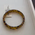 Makroaufnahme eines breiten Harzarmreifs mit Bernstein-Leopardenmuster auf Tablett - Feiner Leopard Armreif (V-36) / Bernstein (Schmaler Stil)