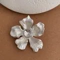 Detailed view of leaf brooch featuring satin petals and a sparkling center rhinestone - Silver
