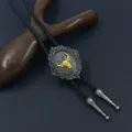 Macro view of Western Bolo Tie featuring golden bull head on a vintage metal slide buckle - Black Rope Gold Bull
