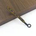 Detail van de etnisch geweven polsband met geometrische patronen en zwarte metalen ring - Meerkleurig J#