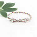 Detailopname van verstelbare regenboog gevlochten armband met zilveren metalen sluiting - Regenboog