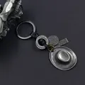 Portachiavi vintage in argento con cappello da cowboy e pelle su sfondo grigio - Argento Antico