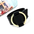 Adjustable black faux leather wide cuff bracelet with a large polished gold metal ring - Black