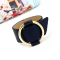 Modern wide navy blue leather bracelet featuring a large polished gold circular metal ring - Navy Blue
