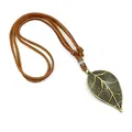 Vintage bronze leaf pendant necklace with brown leather cord on a white background - Leaf