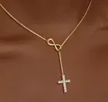 Macro shot of 18K gold infinity symbol and cubic zirconia cross pendant on gold chain - Gold Zirconia Cross