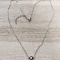 Detail of adjustable evil eye pendant necklace with lobster clasp on wooden background - Black Eye Steel