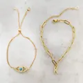 Detail van verstelbare gouden evil eye en kristallen letter K armbandenset - Letter X / Gouden set