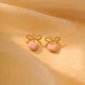 Detail von goldenen Schleifen-Ohrringen mit pfirsichfarbenem Emaille-Herzanhänger - 18K-Gold / Hellrosa