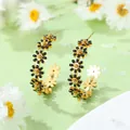 Boucles d'oreilles créoles marguerites dorées avec émail noir sur un fond floral frais - Boucles d'Oreilles Goutte d'Huile Noires