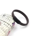 Close-up of brown braided leather bracelet featuring a matte black magnetic metal clasp - Brown