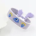 Purple embroidered Evil Eye bracelet with white pearls and adjustable tassel detail - Lavender