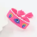 Detail van roze Evil Eye geborduurde armband met parels en kwastjes - Perzik