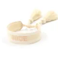 Close-up of beige woven friendship bracelet with NICE embroidery and soft tassels - Off-White NICE