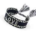 Detail of black and white woven bracelet with LOVE embroidery and fringe tassels - LOVE White Letters / Black