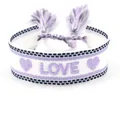 Detail of woven friendship bracelet with purple LOVE embroidery and tassel drawstring - LOVE White Base Purple Letters