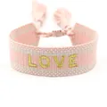 Detail of pink and white woven friendship bracelet with gold LOVE embroidery and tassels - LOVE Pink Base Gold Letters