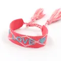 Pink woven friendship bracelet with blue LOVE embroidery and tassel detail in boho style - Rhombus LOVE